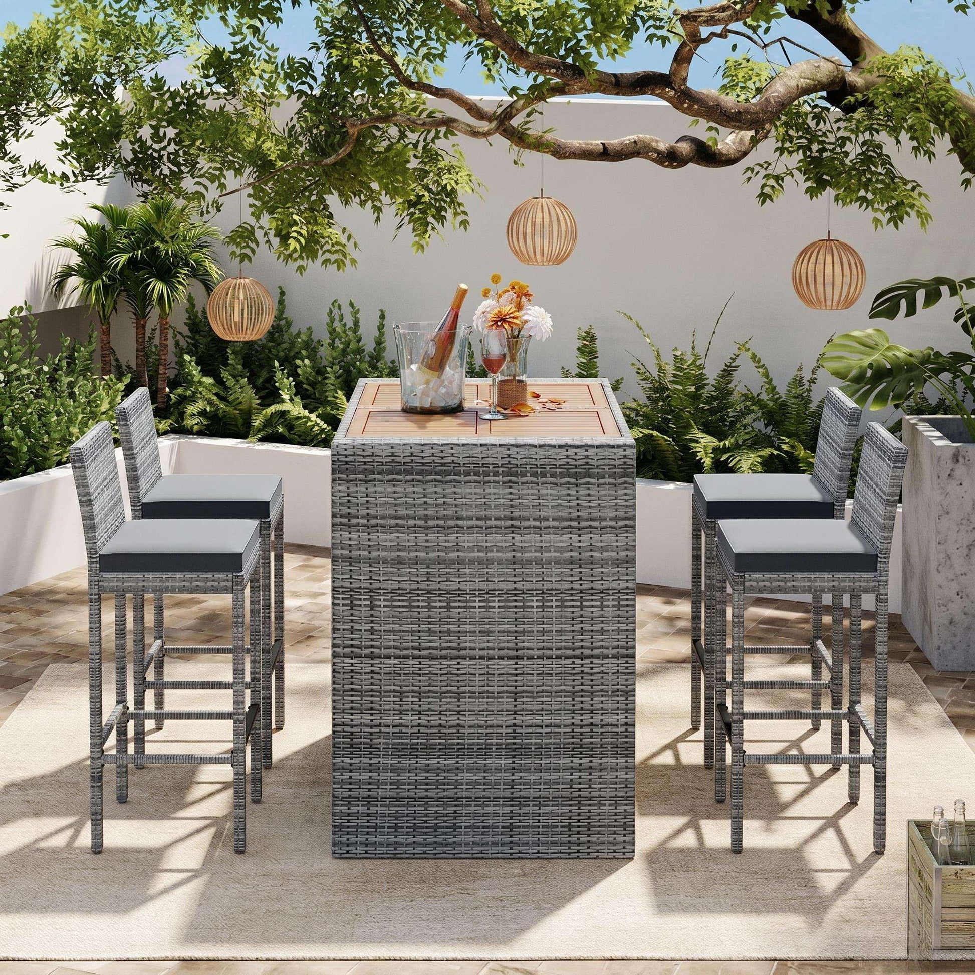 Outdoor patio wicker bar set with gray wicker table, four stools, and acacia top