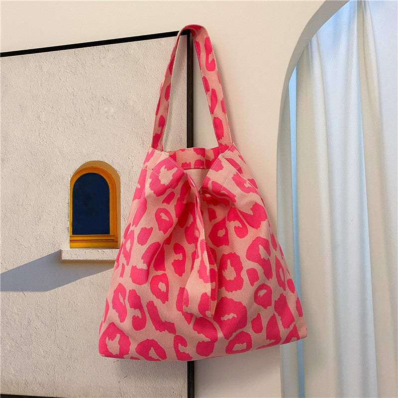 Single-shoulder animal print canvas tote bag, pink and white, side view with loop handle