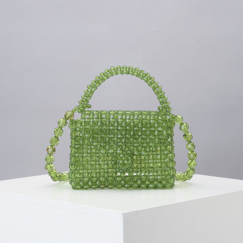 Green beaded mini tote bag with arched top handle and woven mesh bead body