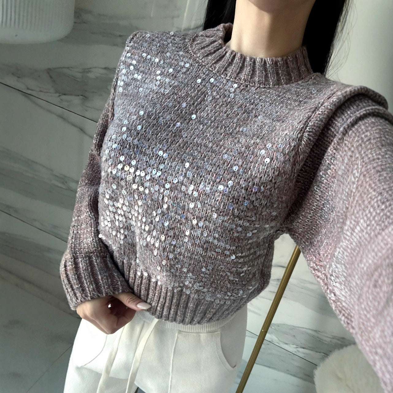 Person wearing a sparkly brown sweater indoors