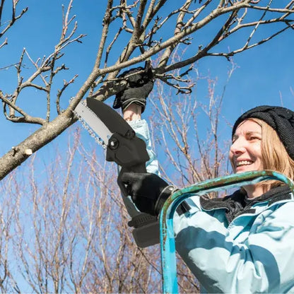 Cordless mini electric chainsaw cutting a tree branch; gloved hand gripping trigger