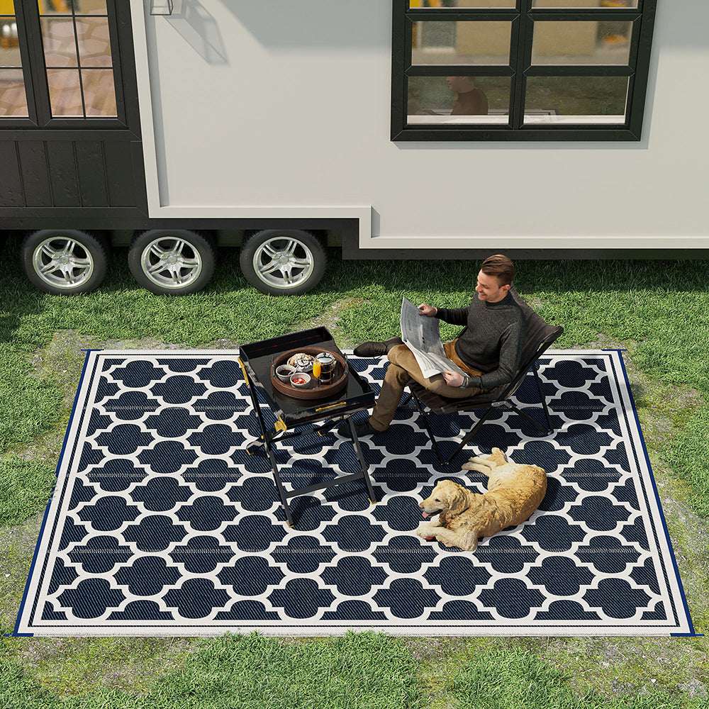Reversible outdoor rug with navy-and-white quatrefoil pattern and bordered edges