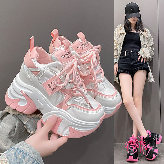 A pair of pink and white athletic shoes with a low-top design and mid heel height, displayed alongside a model wearing the shoes.
