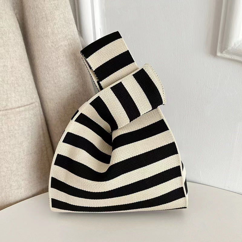 Striped knitted bucket tote bag in black and cream, rounded top and carrying handles