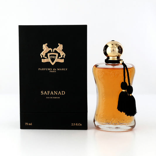 Women's eau de parfum spray bottle with amber glass, gold cap, and black tassel charm