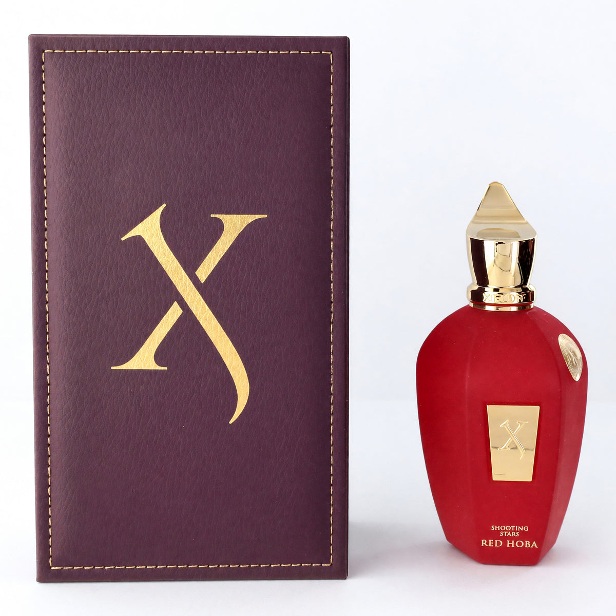 Red Hoba perfume spray bottle with red glass, gold cap, and matching box