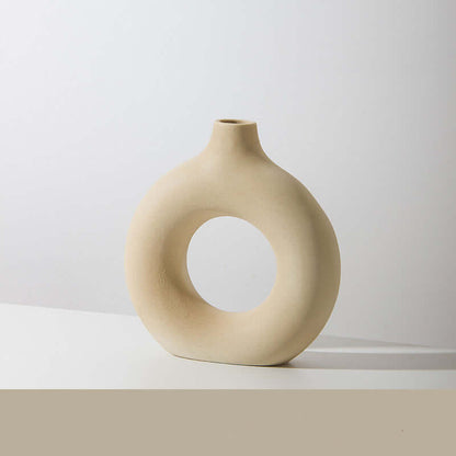 Off-white ceramic vase with circular cutout, curved bulb shape