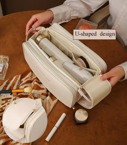 Cream cosmetic bag opened to show multiple inner slots and elastic divider bands