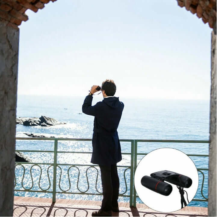 Black binoculars held up to the eyes, orange lens inserts visible