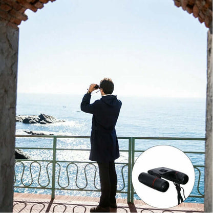 Black binoculars held up to the eyes, orange lens inserts visible