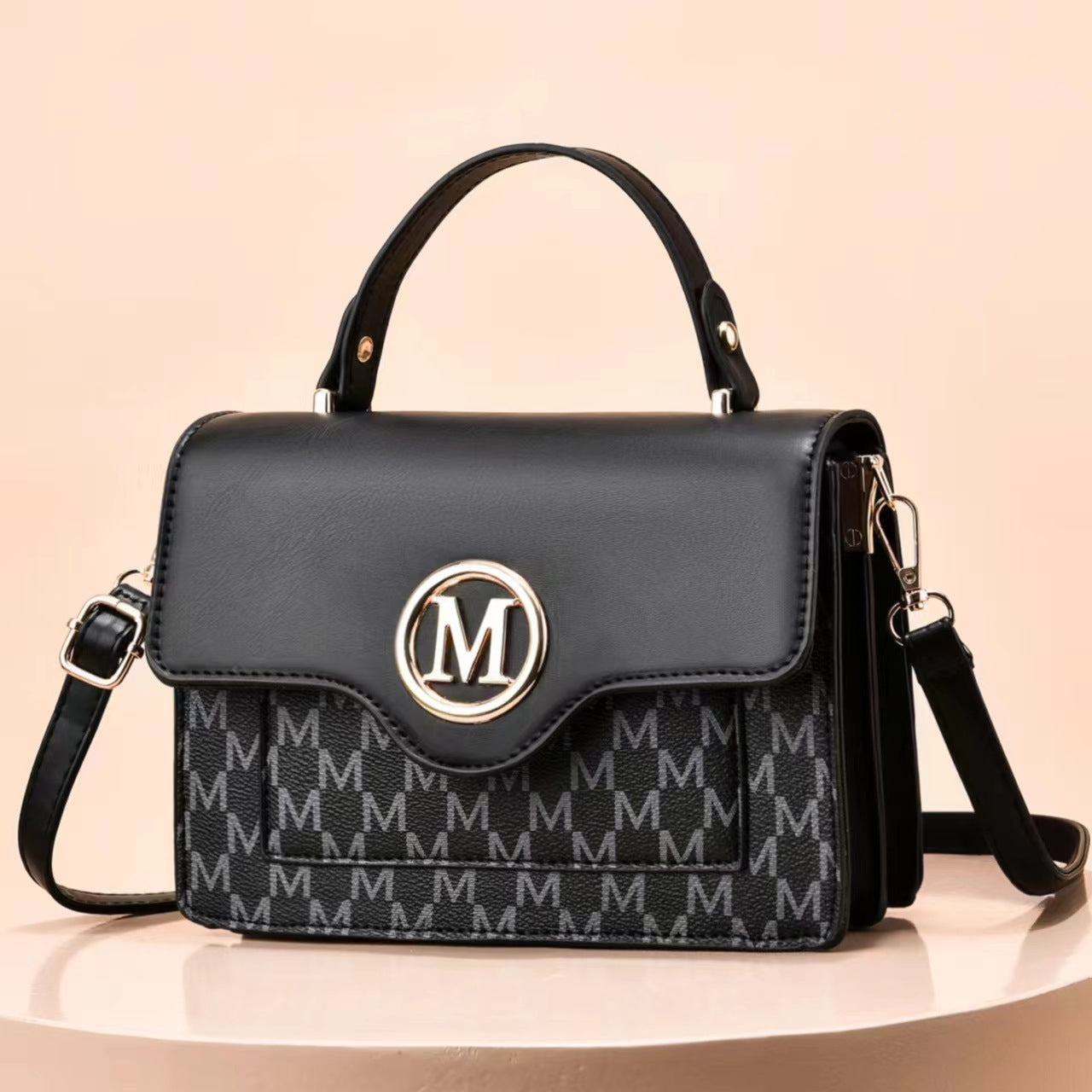 Black printed shoulder bag with flap, top handles, M logo, and crossbody strap