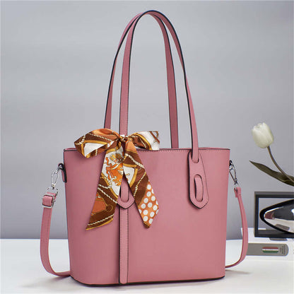 Pink fashion tote handbag with patterned scarf tie, top handles, and shoulder strap