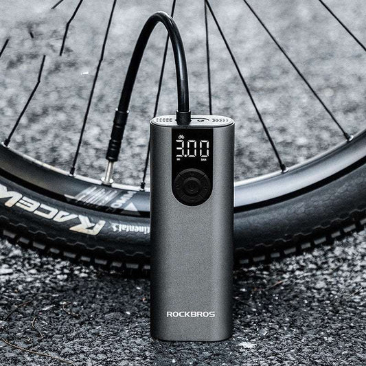 Bicycle tire being pumped up by a ROCKBROS air pump on a road.