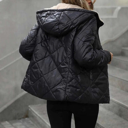 Person wearing a black quilted jacket on a staircase