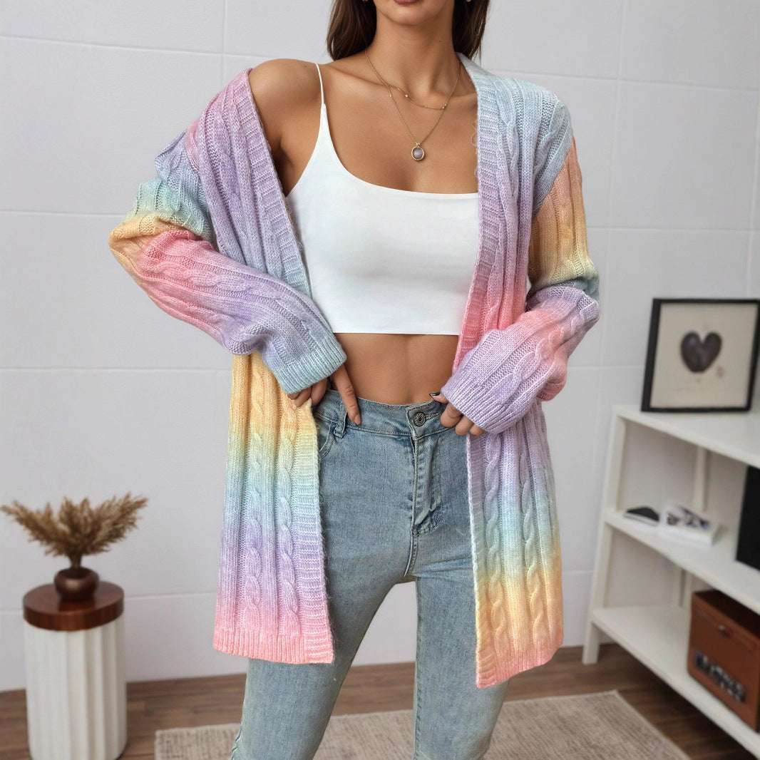 Person wearing a colorful gradient cardigan over a white top and jeans indoors.