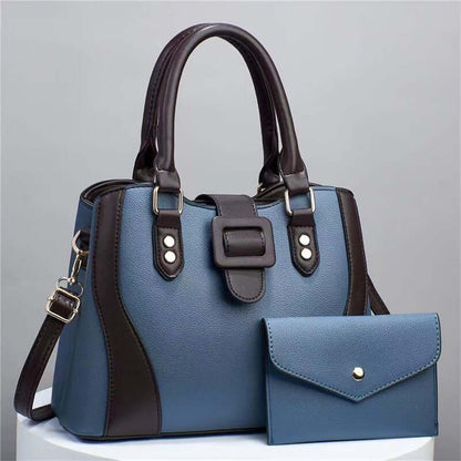 Blue tote handbag with black trim, top handles, and matching envelope pouch