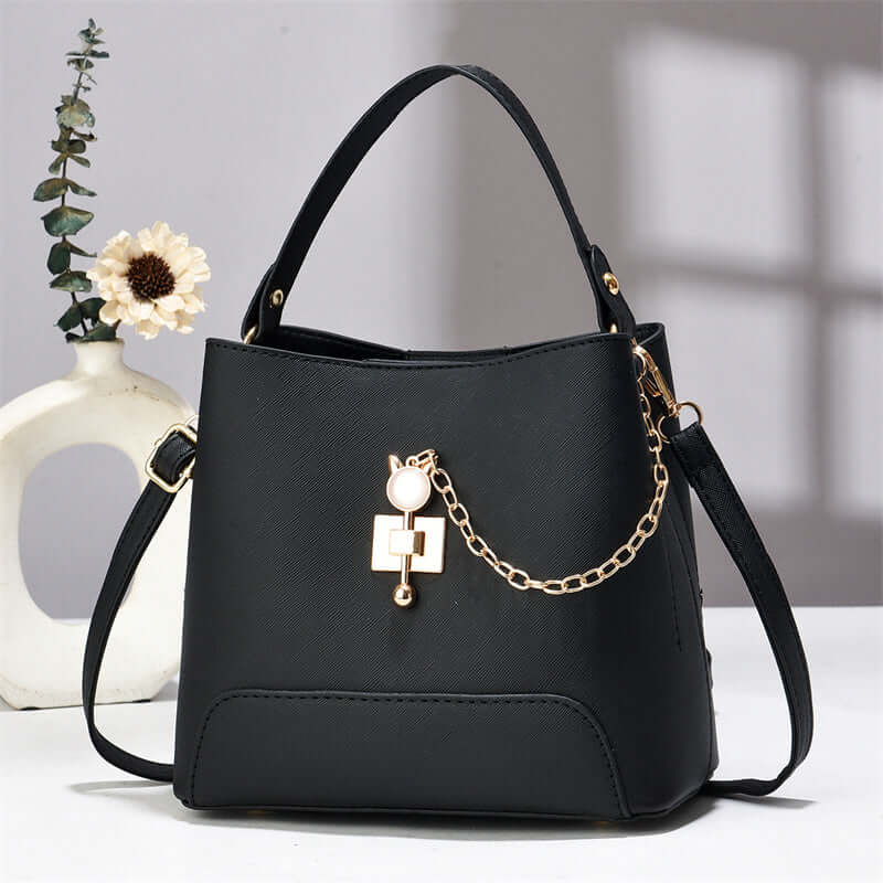 Black PU leather bucket bag with top handle, shoulder strap, and front chain lock charm