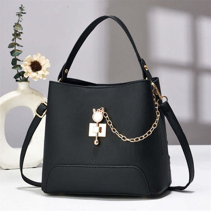 Black PU leather bucket bag with top handle, shoulder strap, and front chain lock charm