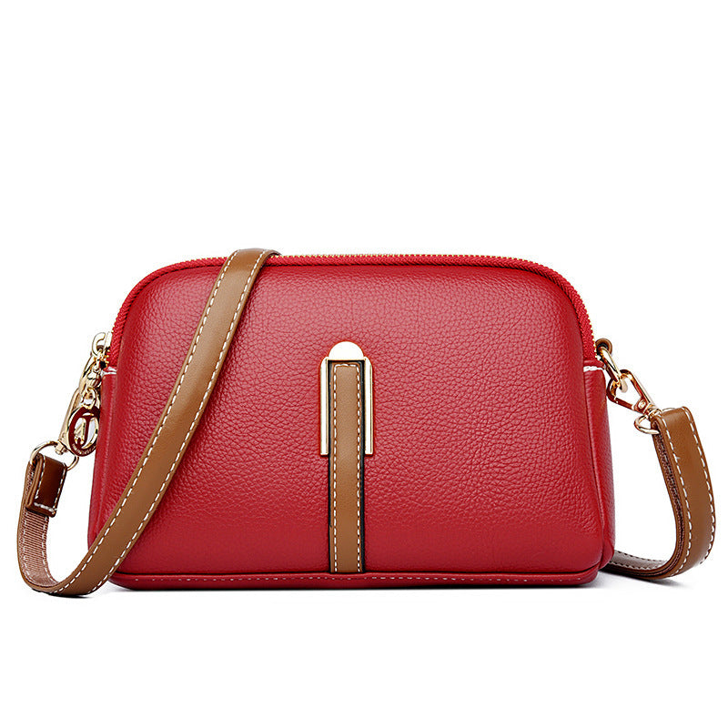 Red textured leather-look shoulder bag with top zipper, front strap detail, crossbody strap