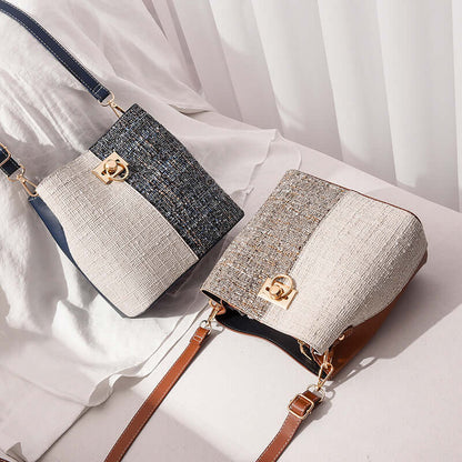 Two-tone textured bucket bag, cream flap and dark speckled front panel with gold clasp, crossbody strap