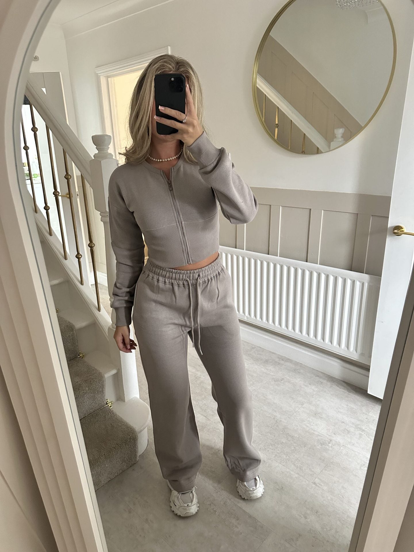 Women’s zip-front sweatshirt and jogger set in light gray, two-piece outfit.