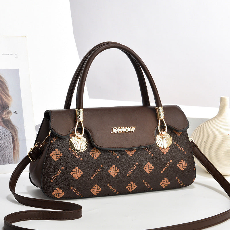 Women’s crossbody handbag in dark brown with letter-style print, flap front, and tassel charms.