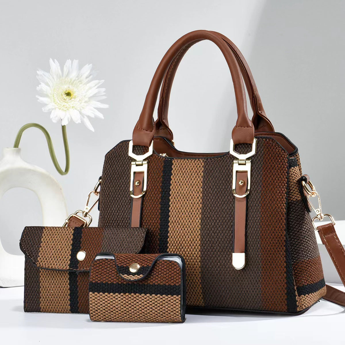 Large canvas crossbody bag in dark brown and beige striped with brown handles and matching pouch bags.