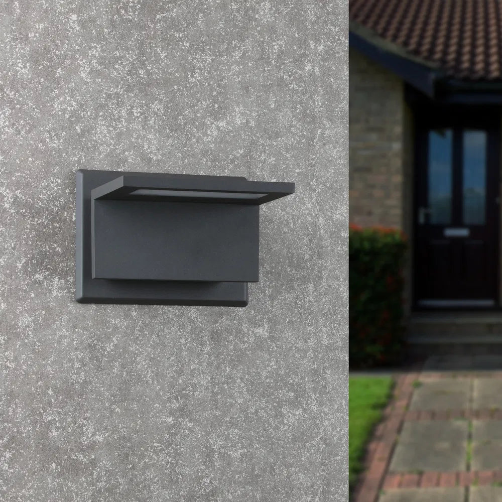 Dark gray modern outdoor wall sconce with rectangular frosted diffuser on wall