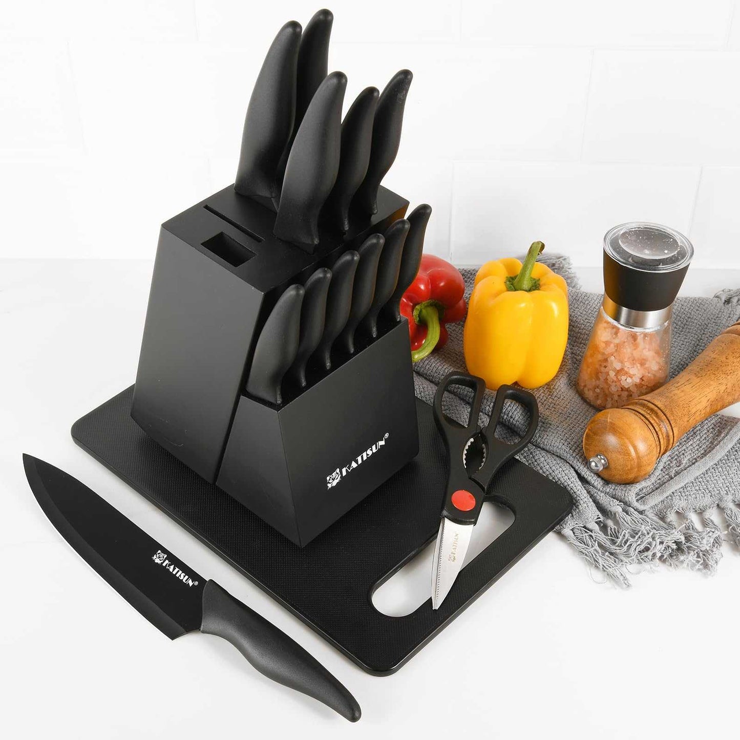 Black knife block with multiple knives and matching black cutting board
