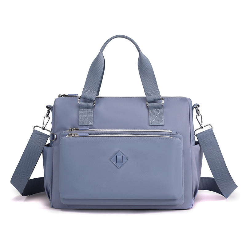 Waterproof nylon one-shoulder bag, light blue, front view with zip pocket