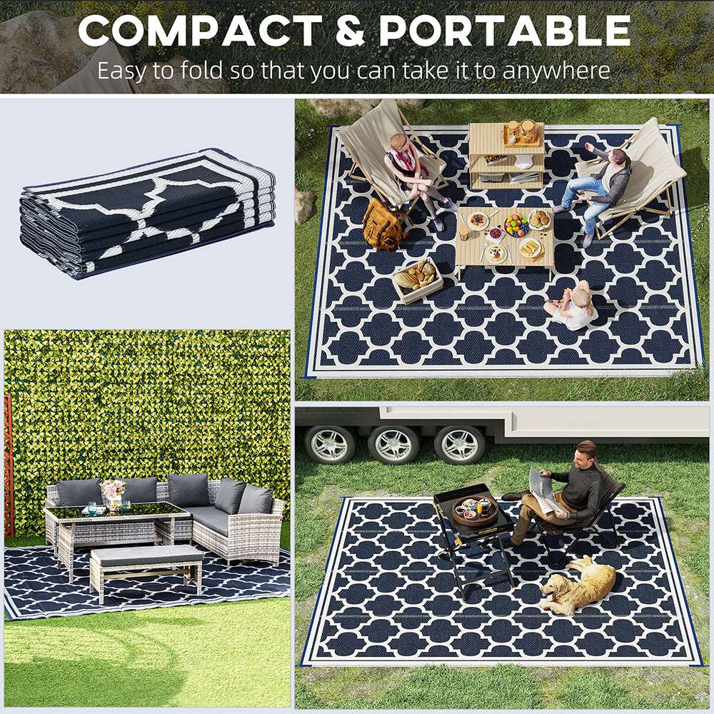 Reversible outdoor rug with black-and-cream quatrefoil pattern on a grass yard