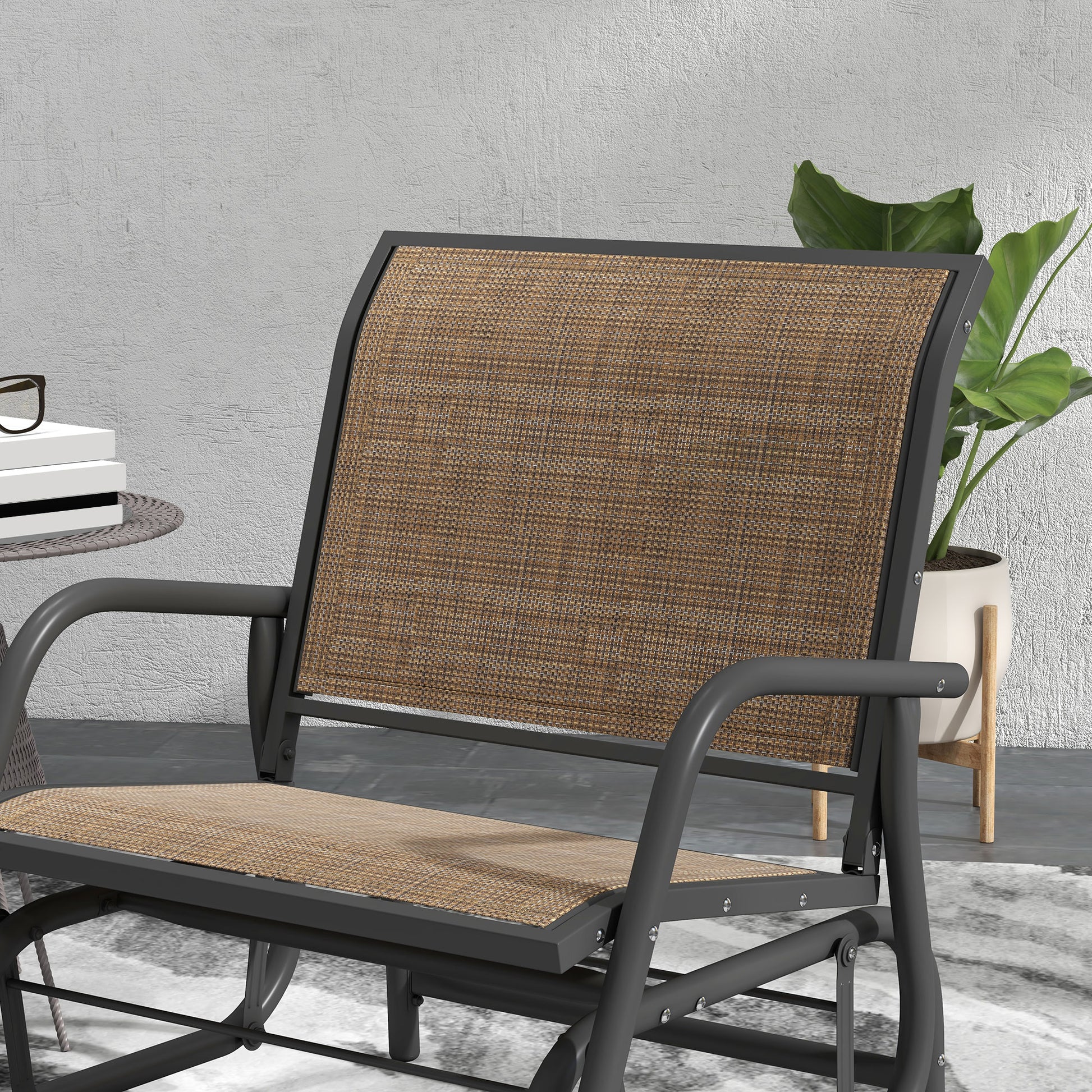 Outdoor steel glider chair close-up with tan woven seat and black curved arm frame