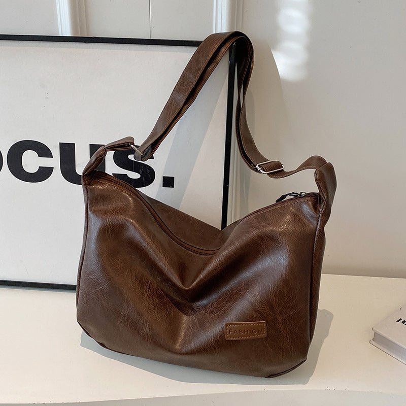 Brown leather-look hobo shoulder bag with long strap, slouch shape and front patch