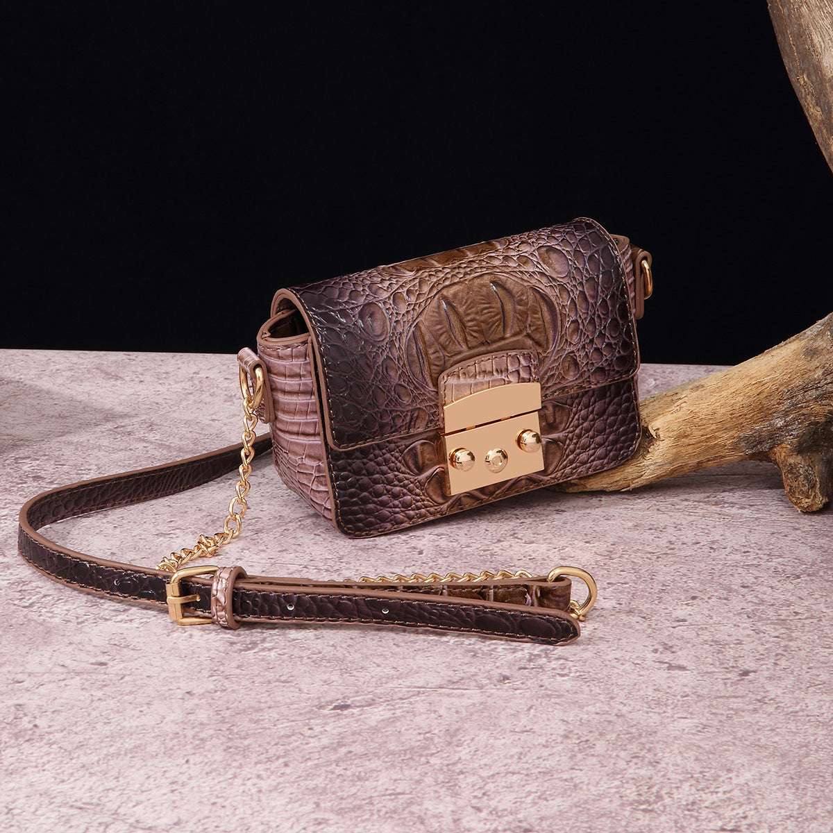 Brown crocodile-textured one-shoulder crossbody bag with gold-tone square clasp and chain strap.