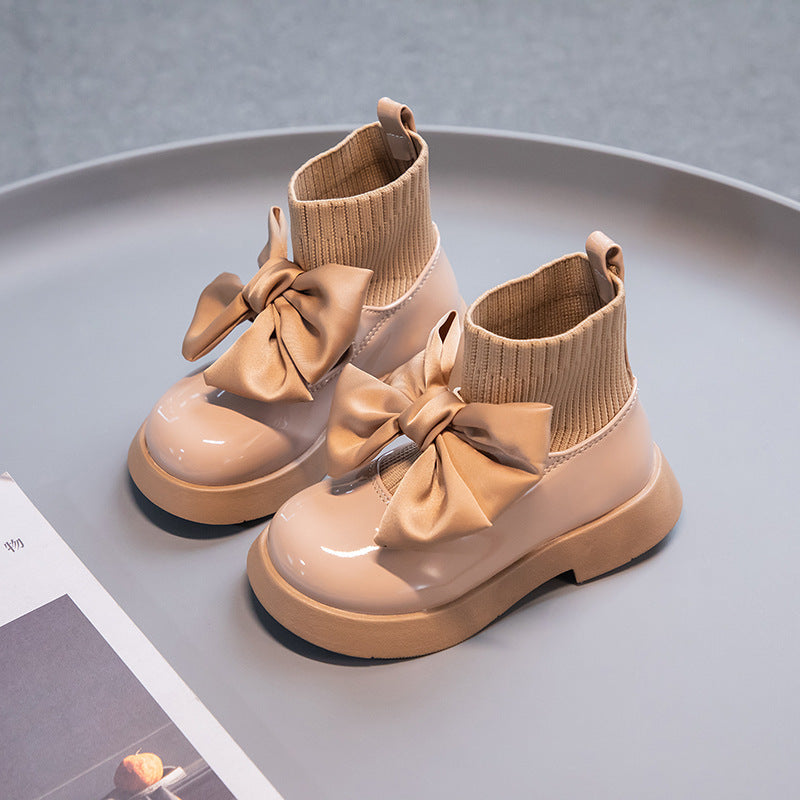 Girls’ tan ankle boots with ribbed knit cuffs, satin bows, and thick rubber sole