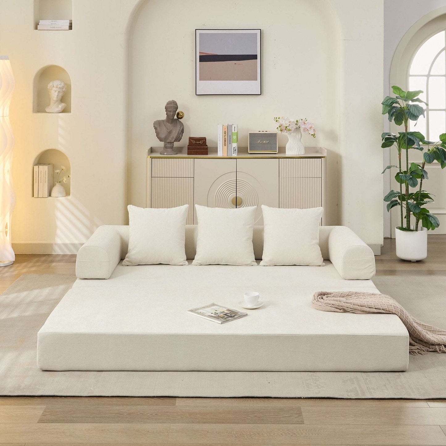 Beige convertible sofa bed open as a flat bed with three back pillows folded down