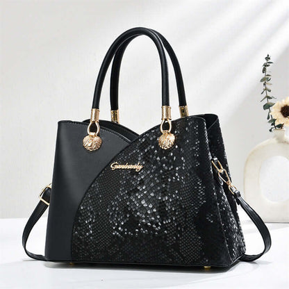 Black stone-pattern tote bag with black handles, gold hardware, and side strap