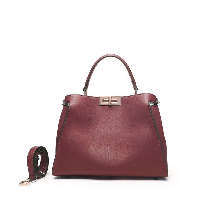 Burgundy crossbody handbag with metal clasp and top handles