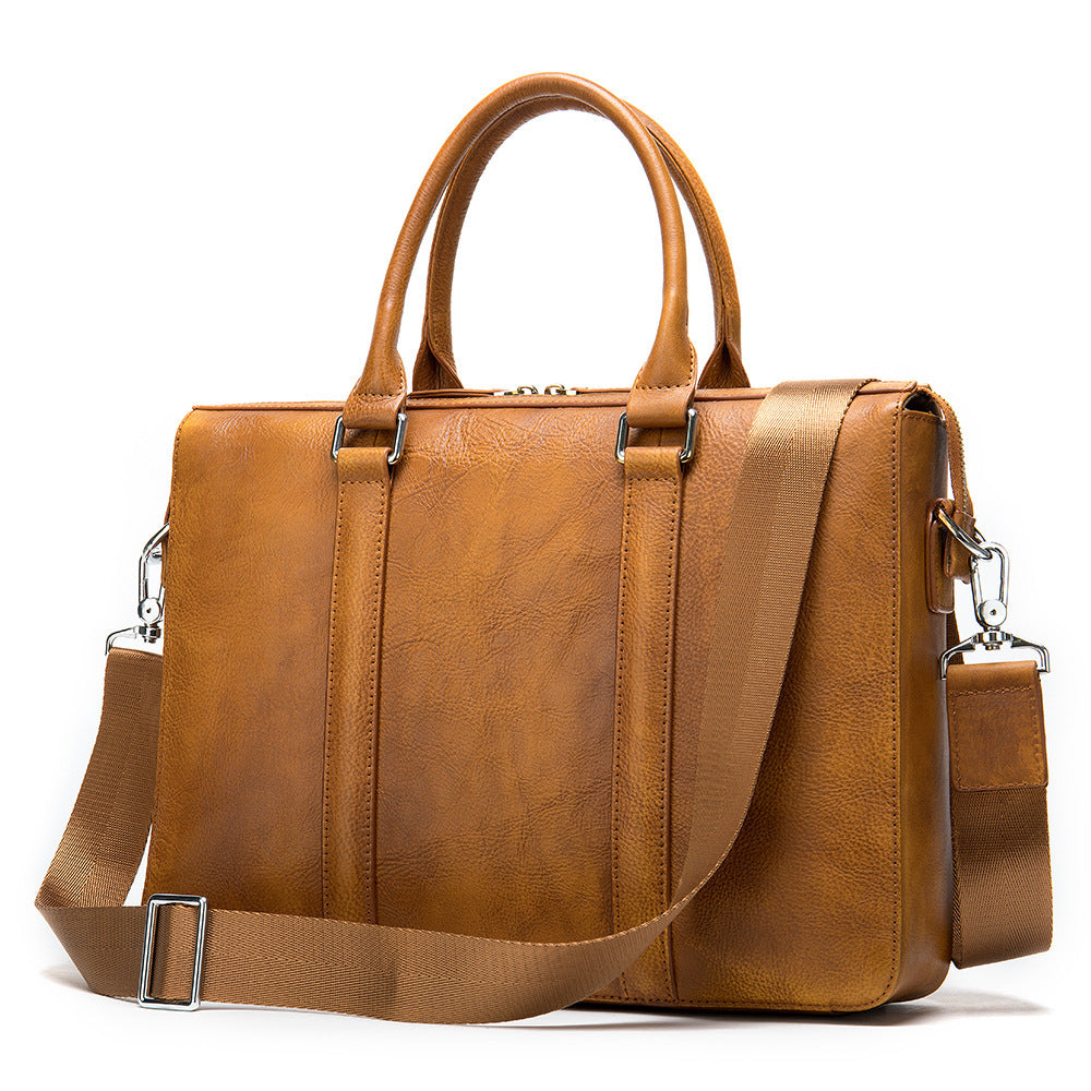 Brown leather briefcase front view with top handles and shoulder strap, metal hardware