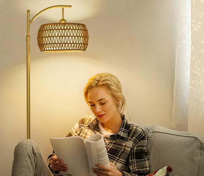 Gold floor lamp with woven shade casting warm light