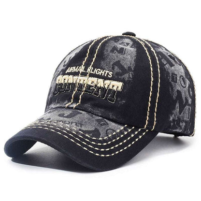 Washed black baseball cap with front logo patch, tan top stitching and curved brim
