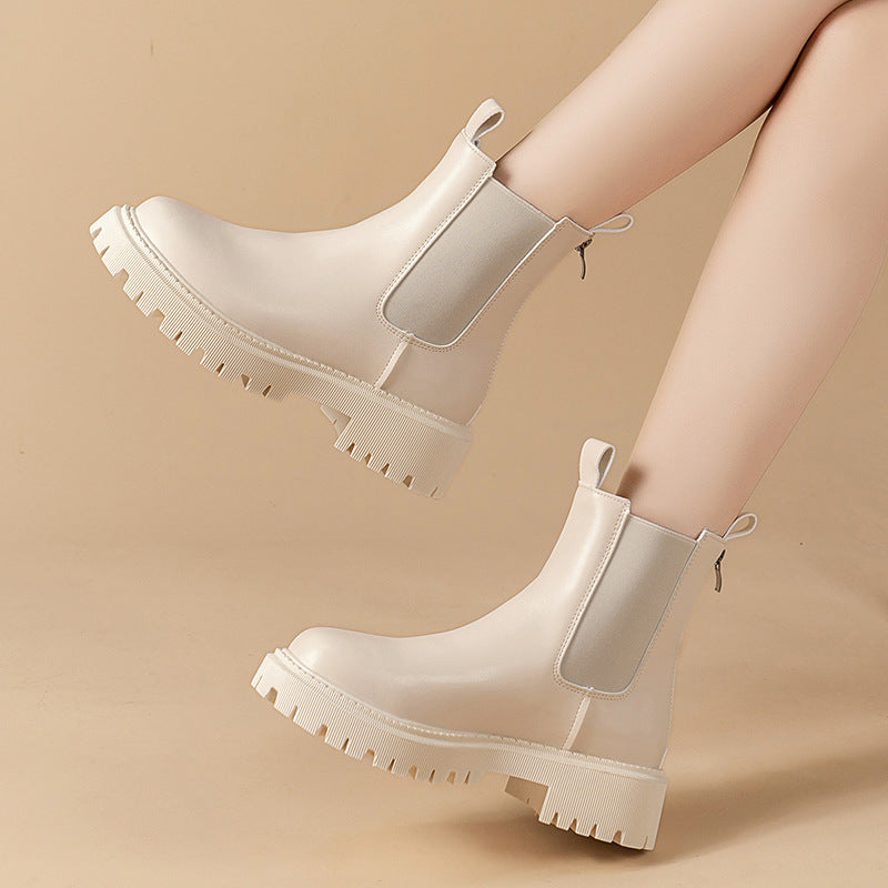 White chunky boots worn by a person on a beige background