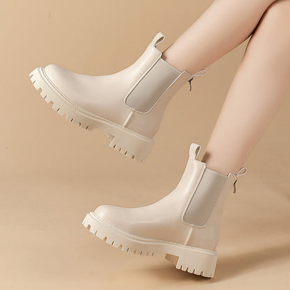 White chunky boots worn by a person on a beige background