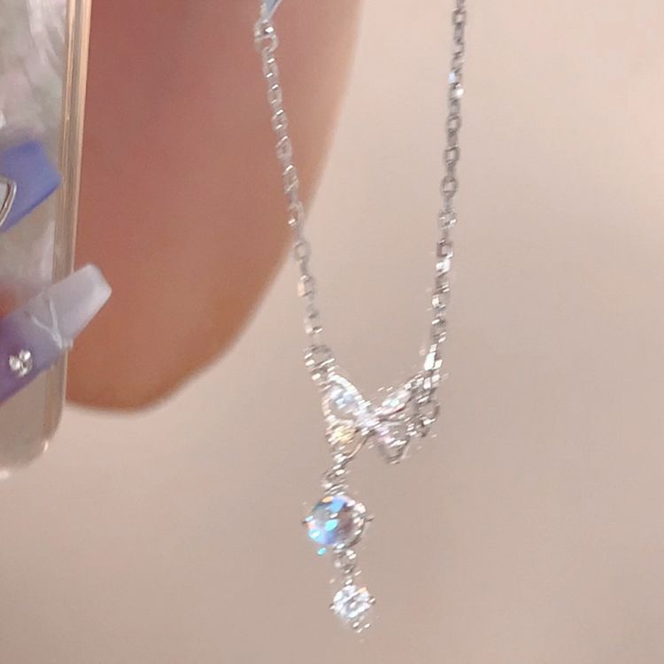 Butterfly charm pearl necklace with long silver chain and blue drop pendant