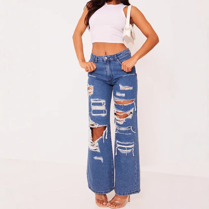 Light blue distressed denim jeans with big patch rips and frayed wide-leg hems