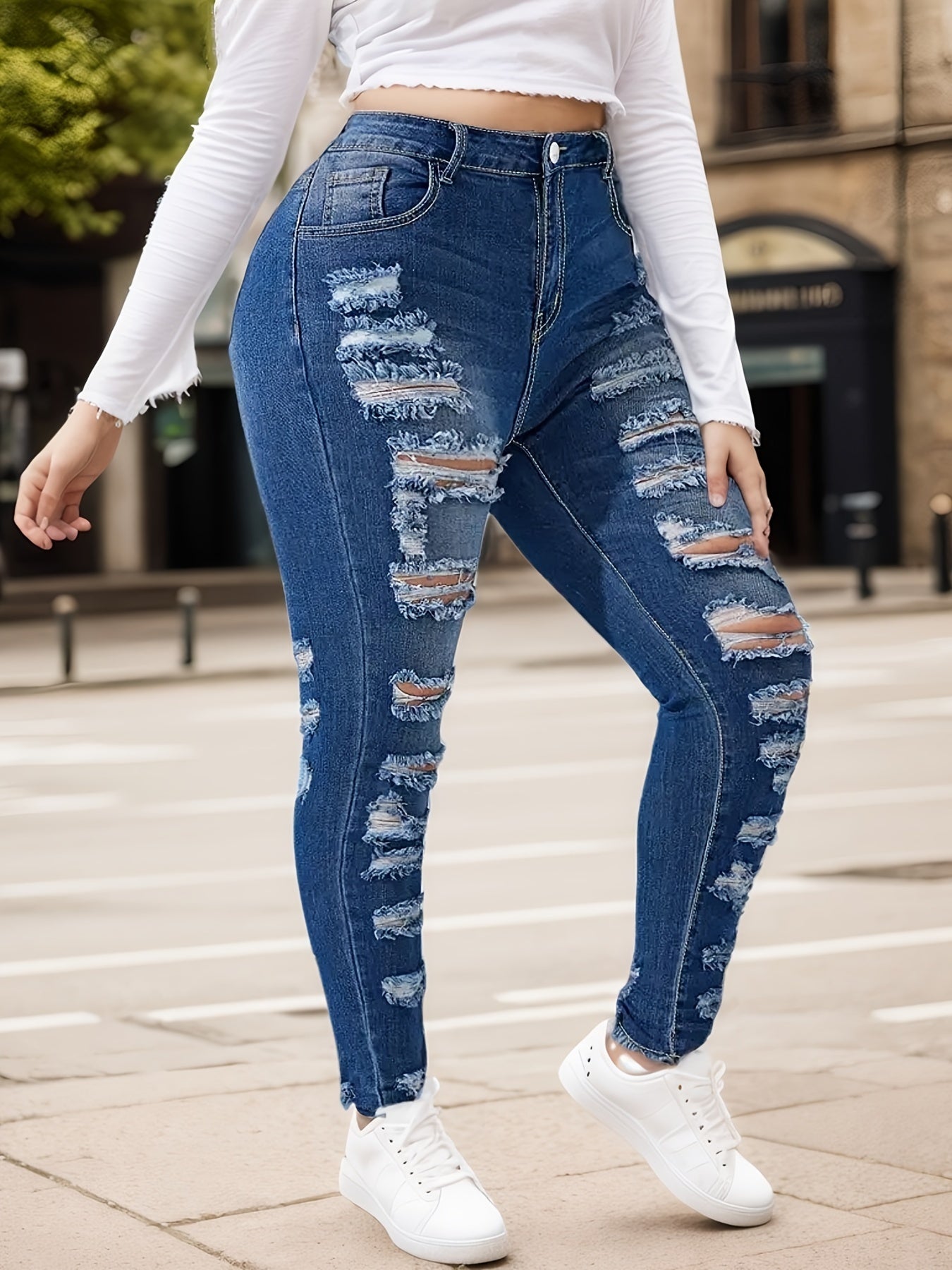 Women's blue ripped skinny jeans with distressed patches and ankle-length skinny fit