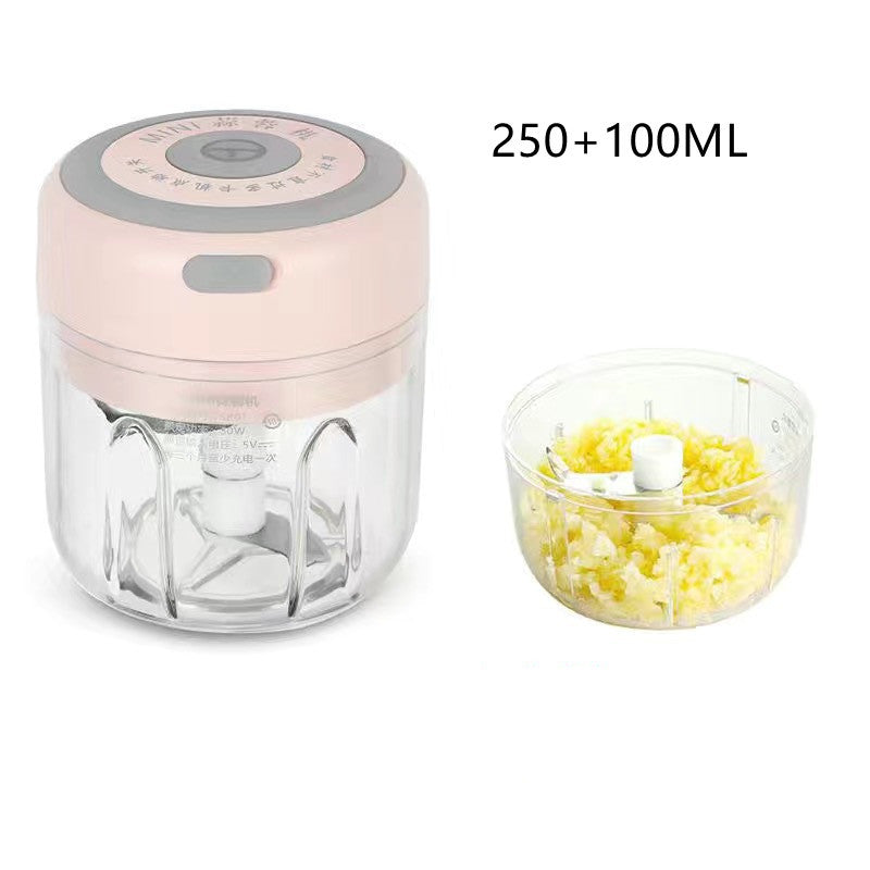 Electric garlic chopper with pink lid and clear bowl, chopped ingredients inside