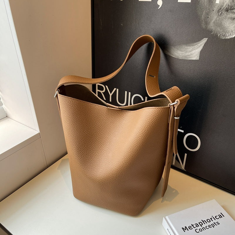 Pebble-grain bucket bag in tan with drawstring top and wide shoulder strap