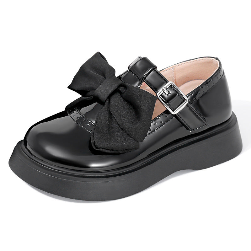 Black Mary Jane bow shoes with quilted vamp detail, front bow, and buckle strap