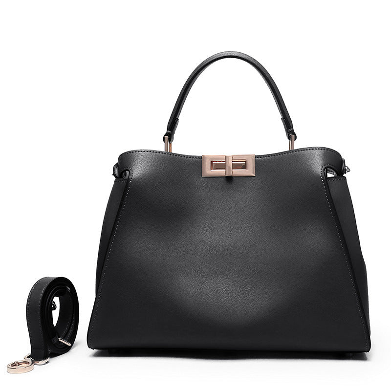 Black crossbody handbag with top handles and rose-gold lock clasp, side view